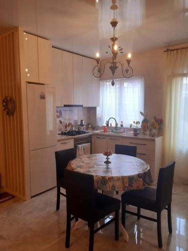 a kitchen with a table and chairs and a refrigerator at Holiday House Spiridi in Batumi