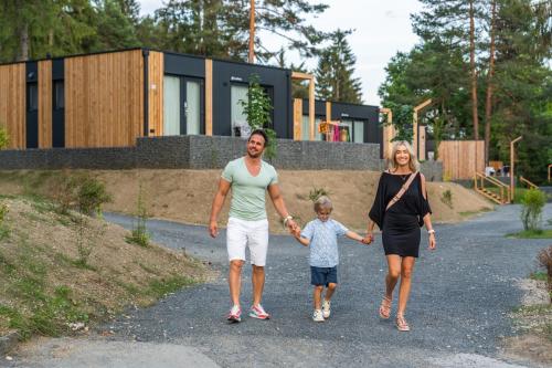 a family walking down a road in front of a house at EuroParcs Pressegger See in Hermagor