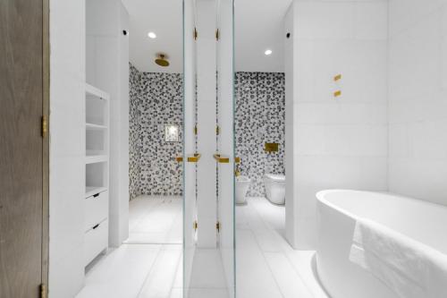 y baño con bañera, aseo y lavamanos. en EDEN'S Homes & Villas - FIVE Palm Residences en Dubái