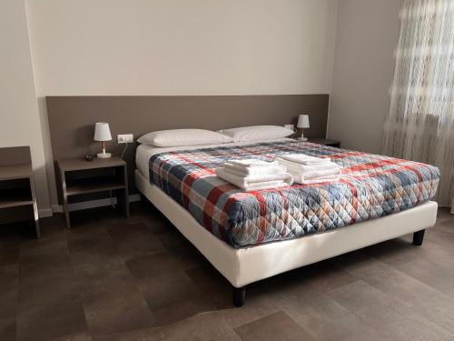 een slaapkamer met een bed met handdoeken erop bij Ferrarin Thiene in Thiene