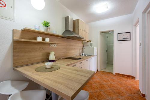 a kitchen with a wooden counter top in a room at Apartments PERA in Selce