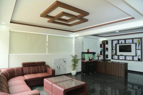 a living room with a couch and a tv at Hotel Bangalore Airport Inn, Near kempegowda Airport, Airport Pickup & Drop Available 24X7 in Bengaluru