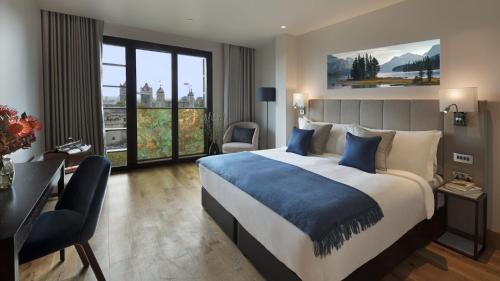 Habitación de hotel con cama grande y escritorio. en Tower Suites by Blue Orchid en Londres