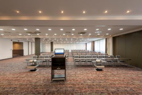 a room with chairs and a podium in the middle of a room at Holiday Inn Munich Unterhaching, an IHG Hotel in Unterhaching