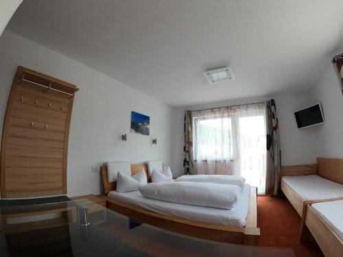 a bedroom with two beds and a couch and a window at Hotel Alpenland in Niederau