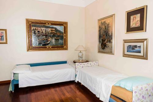 a room with two beds and a painting on the wall at Terrazza Angela in Fiumefreddo di Sicilia