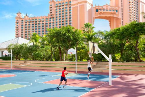 a man and a woman playing basketball on a basketball court at The Royal at Atlantis in Nassau