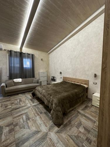 a bedroom with a large bed and a couch at Baglio Bonfiglio in Palermo