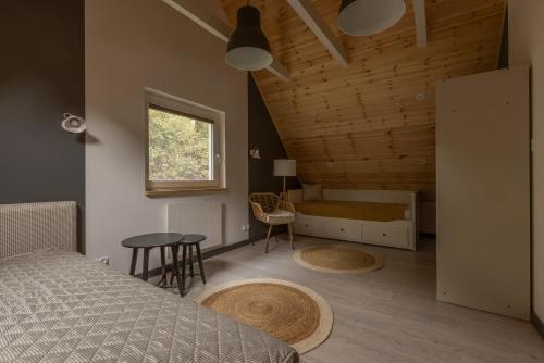 1 dormitorio con cama, mesa y ventana en Czarny Dzięcioł, en Tleń