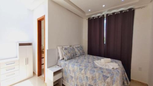 Apartamento a 400 metros da praia de taparapuan في بورتو سيغورو: غرفة نوم صغيرة بها سرير ونافذة