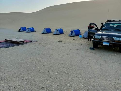 an einem Strand geparkt mit blauen Zelten in der Unterkunft Escape Camp in Bawati