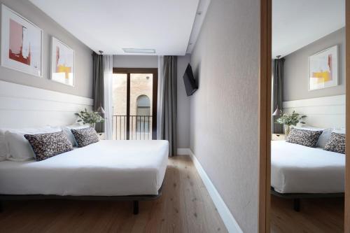 バルセロナにあるnuma I Brioのベッド2台とバルコニーが備わるホテルルームです。