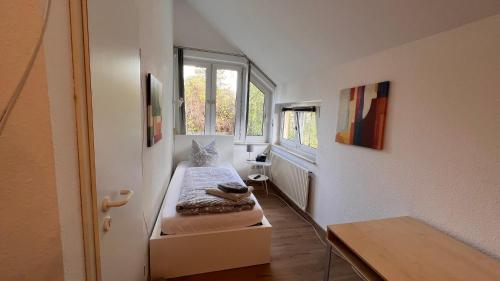 um pequeno quarto com uma cama e uma janela em Apartmenthaus Somborn em Bochum