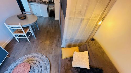 a view of a living room with a table and a chair at LA VILLA DEKO - Studio avec parking proche Université et Hôpital in Beuvry