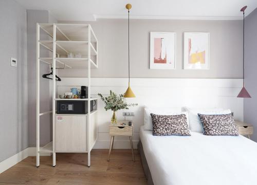 a bedroom with a white bed and a shelf at numa I Brio in Barcelona