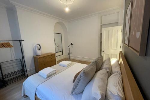 een slaapkamer met een groot wit bed met kussens erop bij Central 1 Bedroom Apartment in Farringdon in Londen