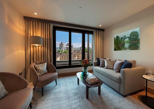 a living room with a couch and chairs and a large window at Tower Suites by Blue Orchid in London