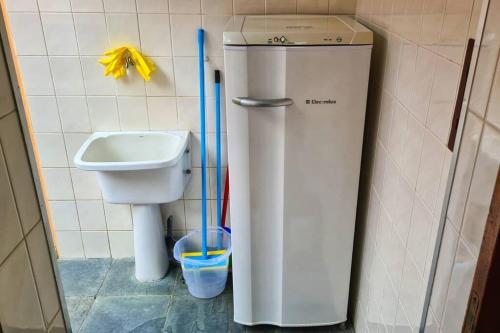 een badkamer met een boiler naast een toilet bij 100mts DA PRAIA com Churrasqueira, Piscina e Wi-Fi in Caraguatatuba