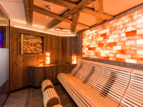 a bench in a room with a brick wall at Hotel Panorama Royal in Bad Häring