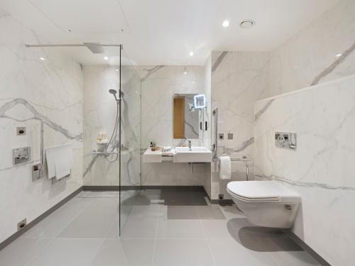 a bathroom with a toilet and a sink and a shower at Tower Suites by Blue Orchid in London