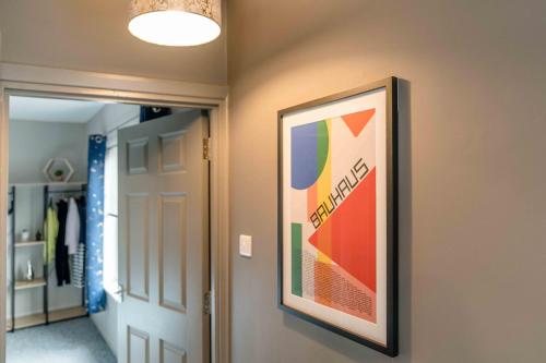 a picture hanging on a wall in a hallway at The Exchange Apartments with Permit Parking in Tewkesbury