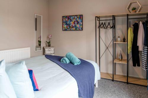 a bedroom with a bed with blue towels on it at The Exchange Apartments with Permit Parking in Tewkesbury