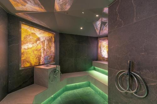 a bathroom with a shower with a green tub at Hotel Panorama Royal in Bad Häring