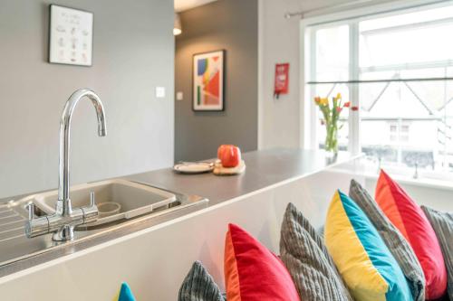 una cocina con almohadas en una encimera junto a un fregadero en The Exchange Apartments with Permit Parking, en Tewkesbury