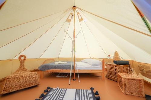 a room with a tent with a bed and chairs at Valea Doftanei Glamping in Teşila