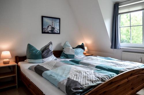 two twin beds in a room with a window at Appartement Fördetraum am Strand von Wassersleben App 9 in Harrislee