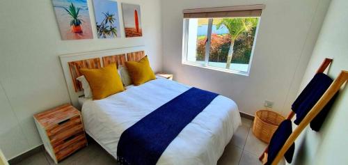 a bedroom with a bed with yellow pillows and a window at Breathtaking 3 Bedroom unit with amazing sea views in Ramsgate