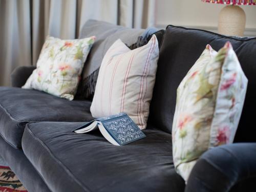 a book sitting on top of a couch with pillows at Arrow Lodge at Ragley Estate in Weethley