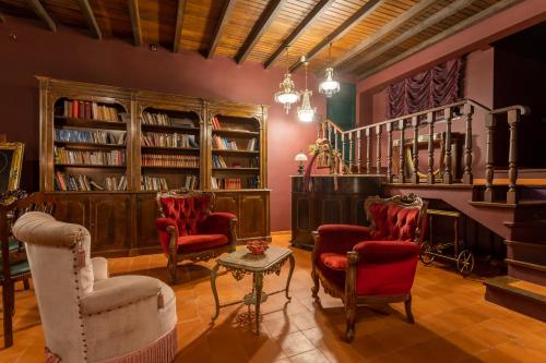 a living room with chairs and bookshelves at Chambre Romantique "La Pompadour" - La Vénus de Lisbonne in Calhandriz