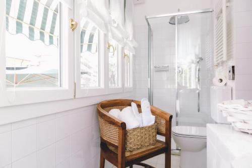 a bathroom with a toilet and a basket of towels at Eveline Portosole Hotel in Sanremo