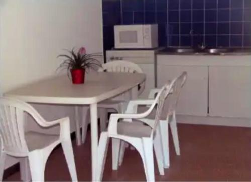une table blanche et des chaises dans une cuisine dans l'établissement Maison cosy avec vue sur la mer à Pietrosella, 60 m²., à Pietrosella