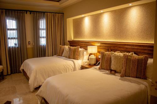 a hotel room with two beds and a large window at HC HACIENDA CATRINA HOTEL BOUTIQUE in Silao