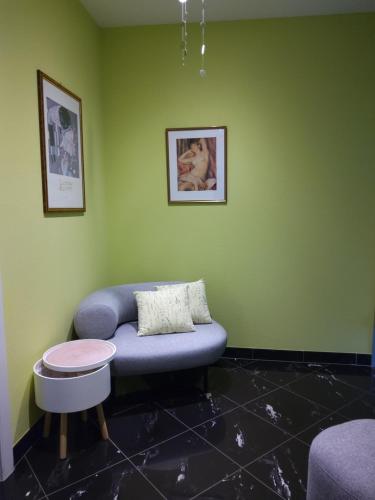 a living room with a blue couch in a green wall at B&B on Top in Sirnach