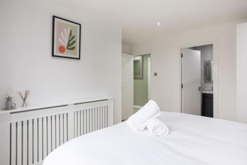 a white bedroom with a white bed and a kitchen at Fabulous Modern Luxury Apartment Sleeps 6- Parking in Belfast