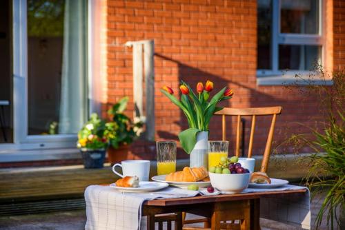 a table with food and flowers on a patio at Fabulous Modern Luxury Apartment Sleeps 6- Parking in Belfast