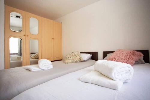 a bedroom with two beds with towels on them at Cozy 3-Bedroom Home in Luton in Luton