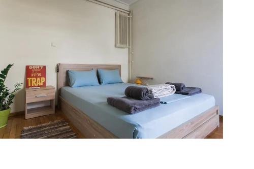 a bedroom with a bed with blue pillows on it at Central faliro Apartment near to marina in Athens