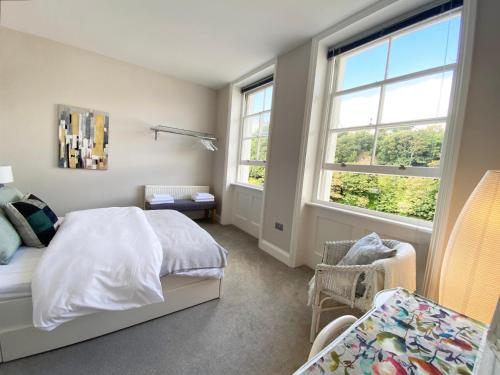 a bedroom with a bed and two windows at Spacious 2BD Flat with Stunning Views Folkestone in Folkestone