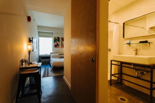 ニューヨークにあるSelina Chelseaの洗面台とバスルームが備わるホテルルームです。