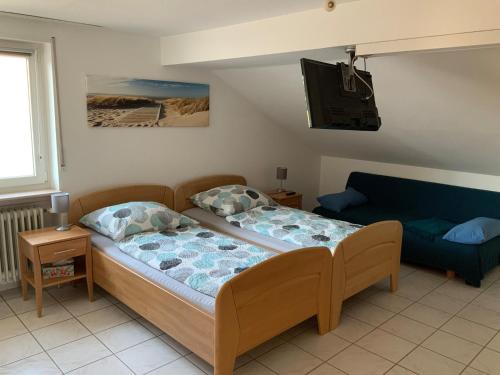 1 dormitorio con 1 cama y 1 sofá en Apartment und Ferienwohnung Mackenbach, en Mackenbach