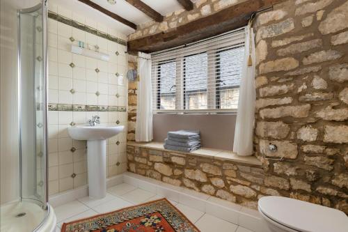 a bathroom with a sink toilet and a window at Badgers Hall in Chipping Campden