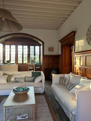 a living room with two couches and a table at O'Cottage double jardin in Annonay