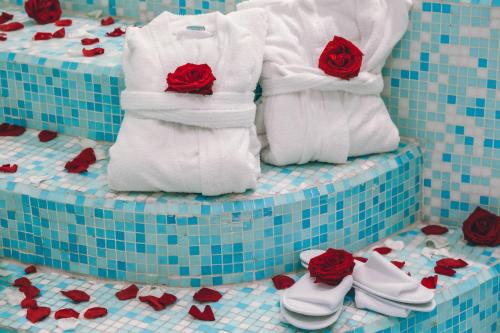a group of towels with red roses on them at Eveline Portosole Hotel in Sanremo