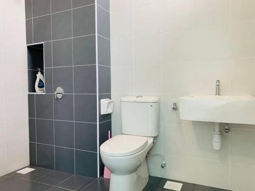 a bathroom with a toilet and a sink at Brand New Cozy home Desaru Pengerang near Sebana Cove Resort in Pengerang