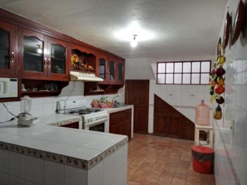 uma cozinha com armários de madeira e um balcão branco em Casa amplia en Cuernavaca em Cuernavaca