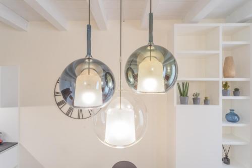 una cucina con tre luci appese al soffitto di Modern & Stylish Apartment in Como City by Rent All Como a Como